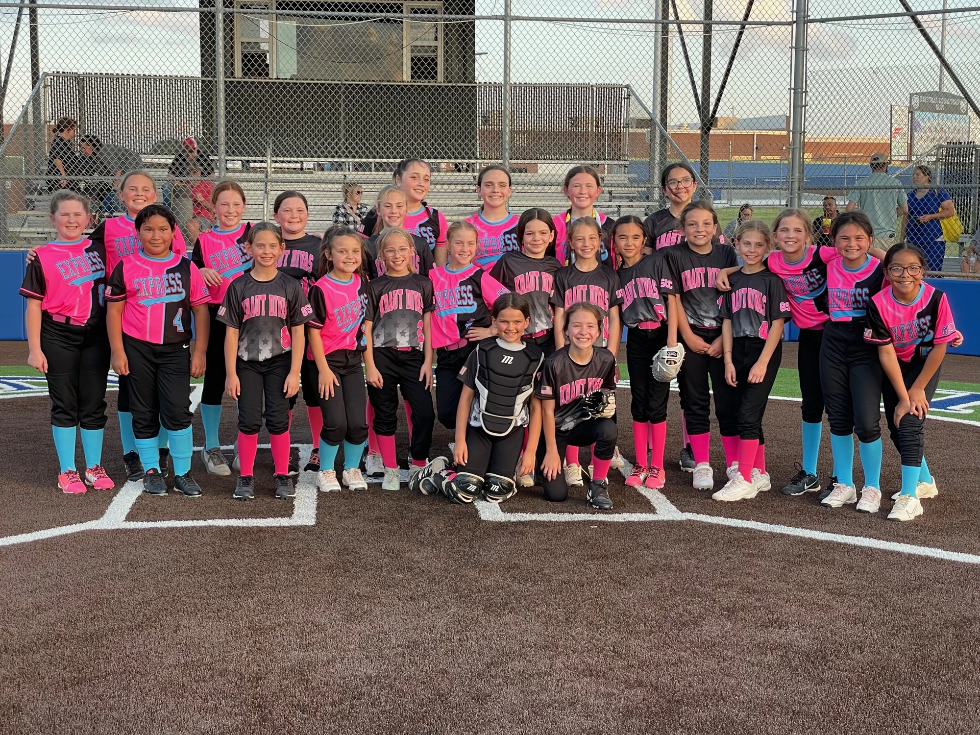 Young softball players posing together on the field.